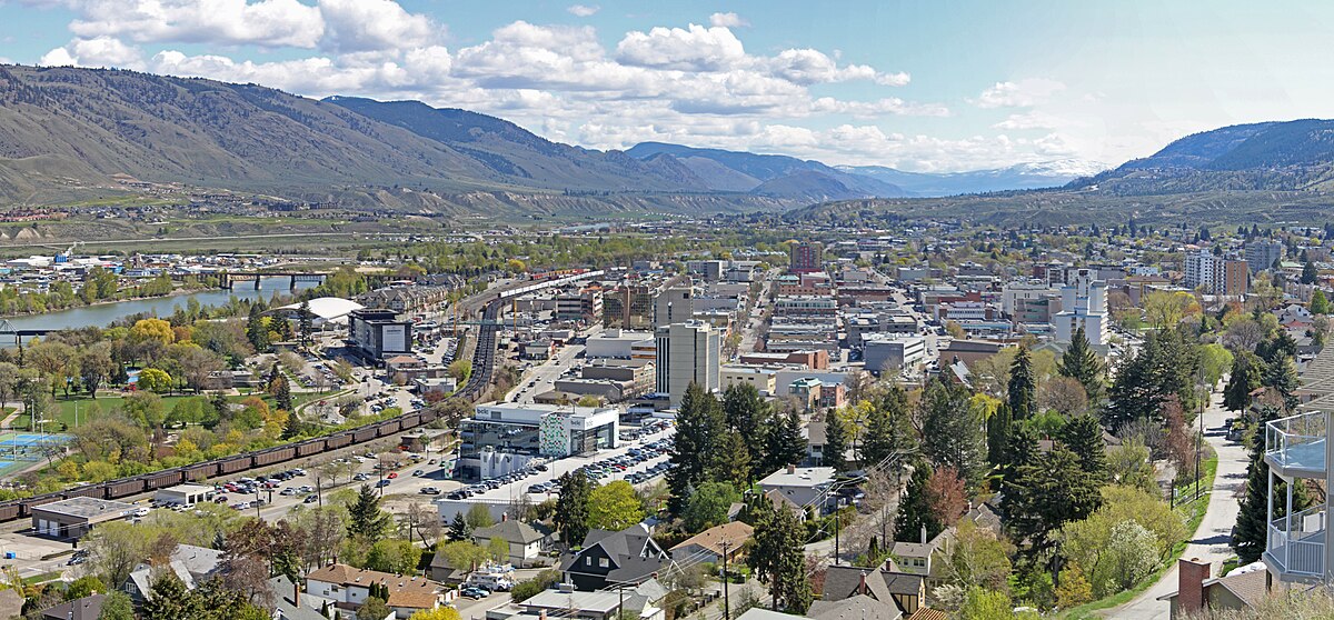 A scenic view of downtown Kamloops, BC, with mountains and rivers in the background.